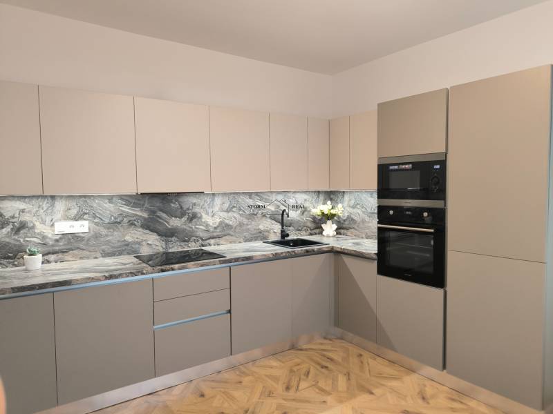 A kitchen in a 4-room apartment with a marble countertop and a wooden decor floor.