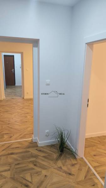 Interior of a 4-room apartment with a wood-patterned floor and white walls.