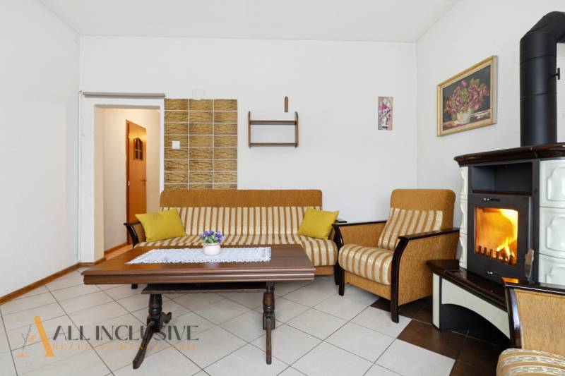 Living room in a family house with a fireplace, striped sofa, and coffee table.