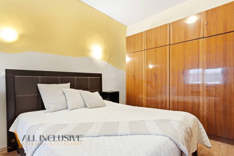 Bedroom with a bed and built-in wardrobe, Family house. Neutral colors, floor with wood decor.