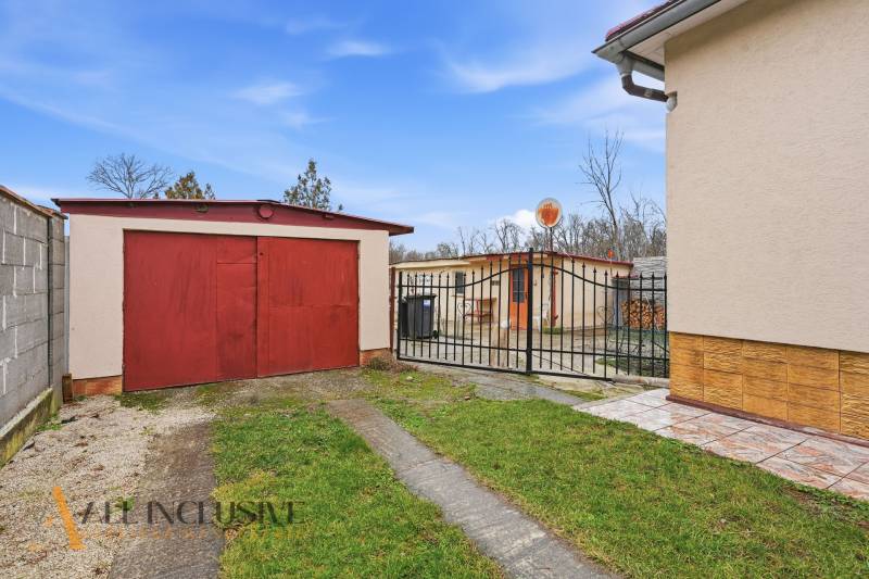 Garage and gate at a family house in Čierny Brod, surrounded by greenery.