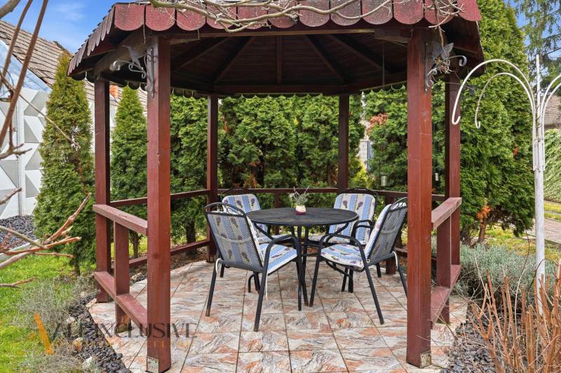 A wooden gazebo in the garden of a family house in Čierny Brod with outdoor seating.