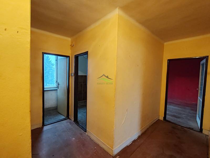 A hallway with three rooms in a 2-bedroom apartment with a wood-patterned floor.