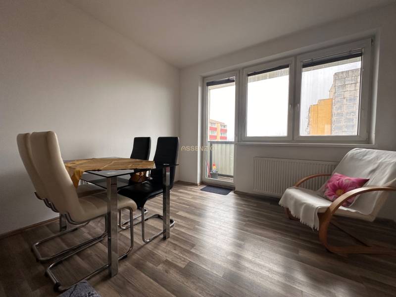 Dining area with a table and chairs in a 3-room apartment, floor with wooden decor.