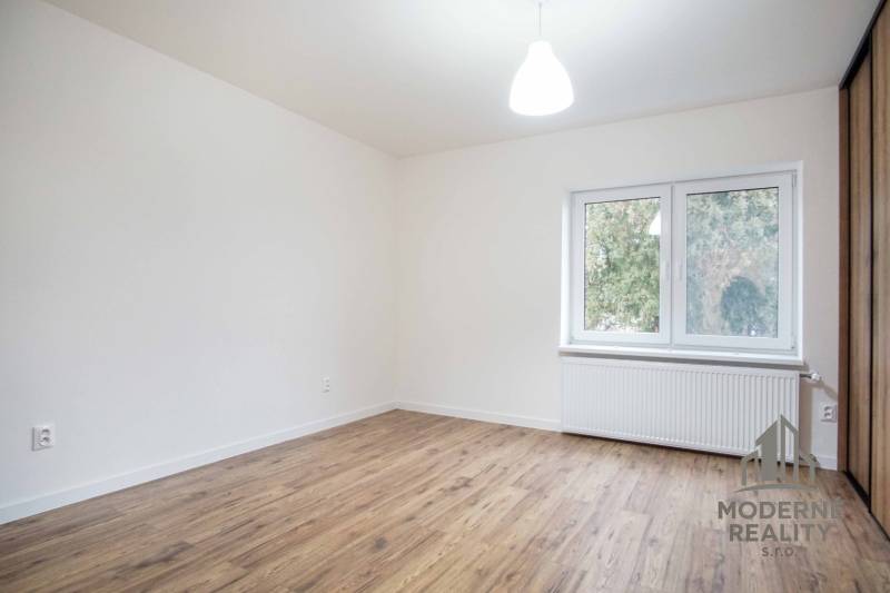 A room in a family house with electrical outlets and a floor with a wooden decor.