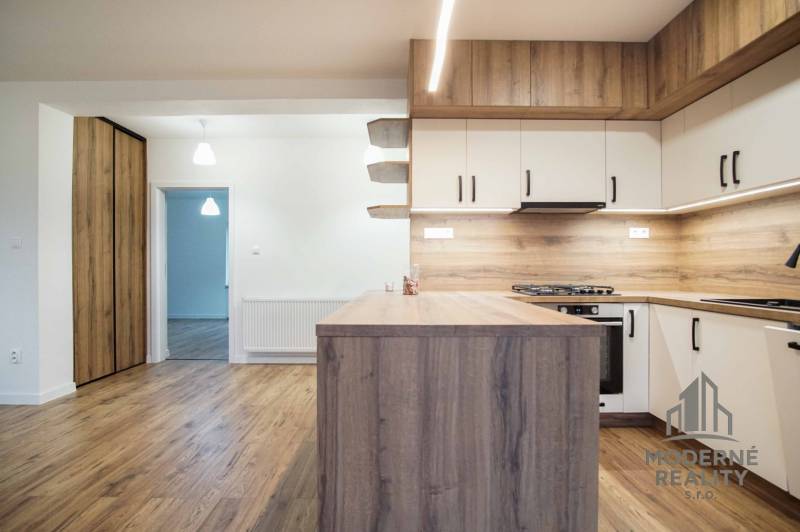 A kitchen in a family house with a wooden decor floor and wooden cabinets.