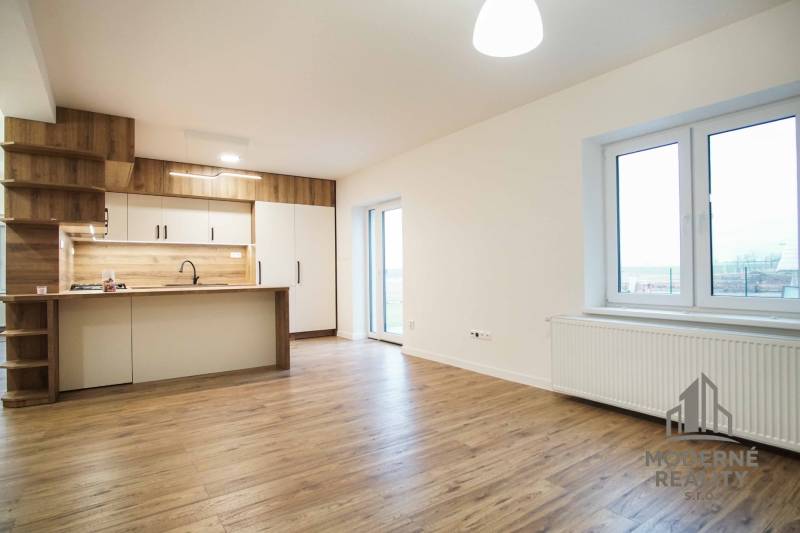 A kitchen in a family house with white cabinets and a wooden decor floor.