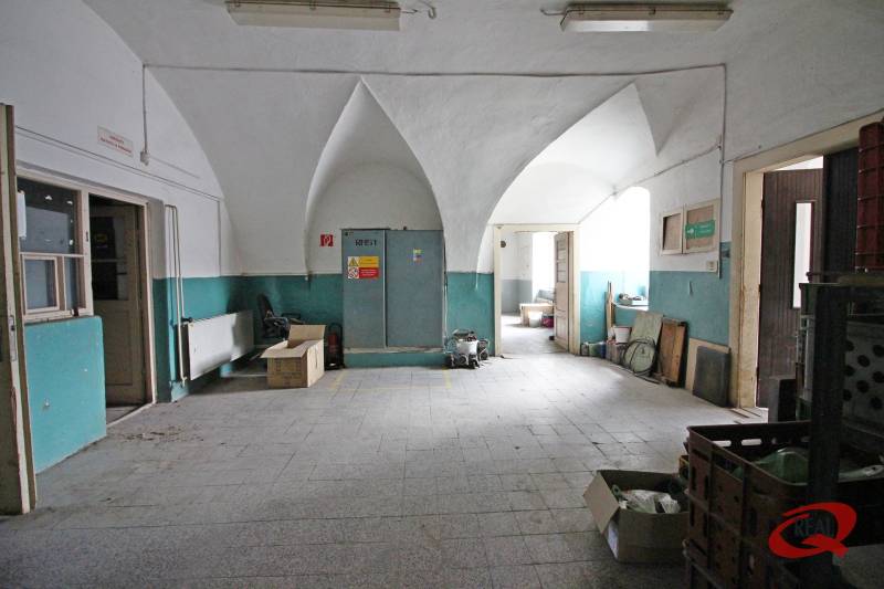 The interior of a building with a vaulted ceiling and a gray tiled floor.