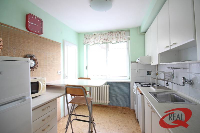 Kitchen in a 3-room apartment, with a gas stove, dining table, and appliances.