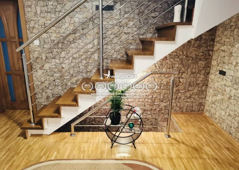 A staircase in a family house with a stone wall and a wooden decor floor.