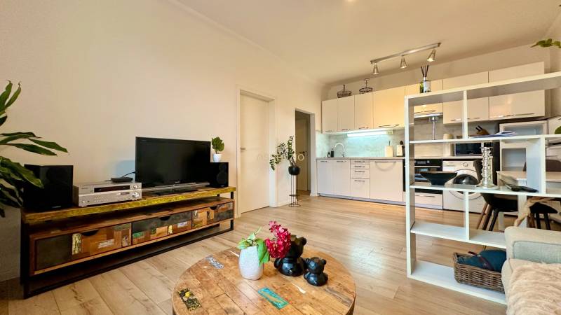 Living room in a two-room apartment with a wooden decor floor, tastefully furnished and cozy.