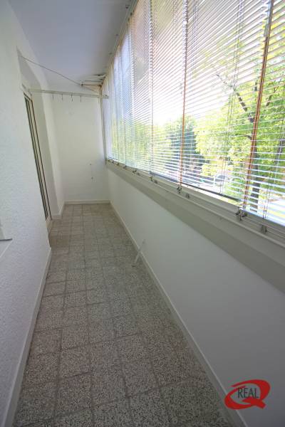 Glazed loggia with terracotta tiles, blinds, and a view, suitable for a 3-room apartment.