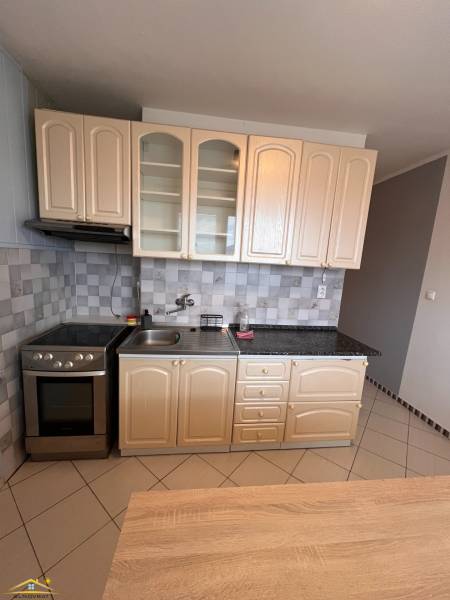 A kitchen unit in a 2-room apartment with tiles and a gas stove.