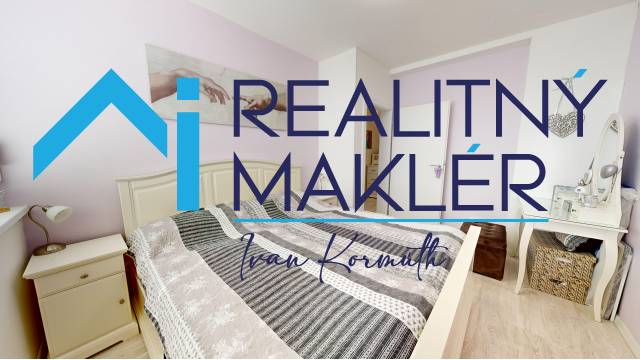 Bedroom in a family house with decorative textiles and a wooden-patterned floor.