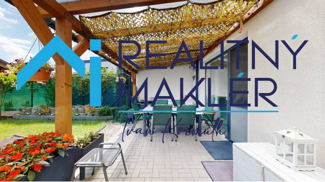Terrace of a family house in Stupava with a pergola, chairs, and greenery in the garden.