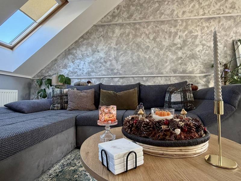 Living room in a two-room apartment with decorative pillows on the sofa and candles on the table.