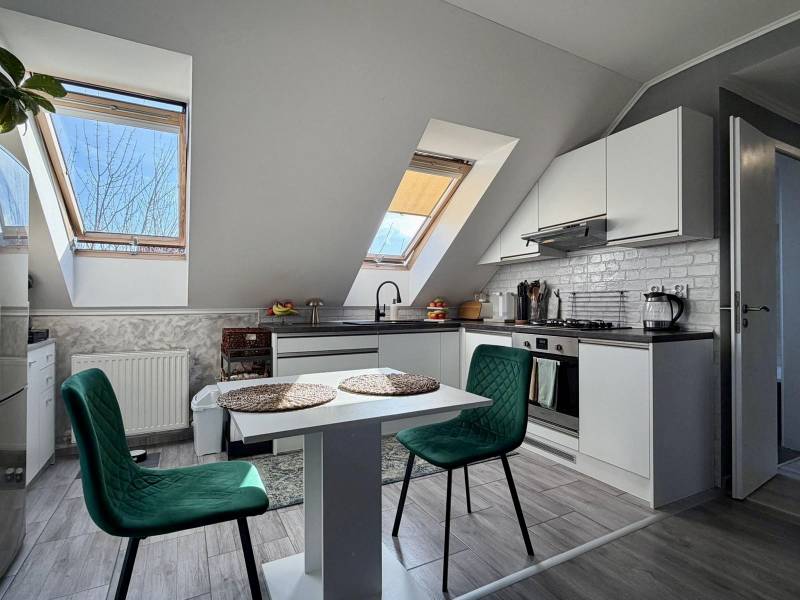 Kitchen in a 2-room apartment with a wooden decor floor and a table with chairs.