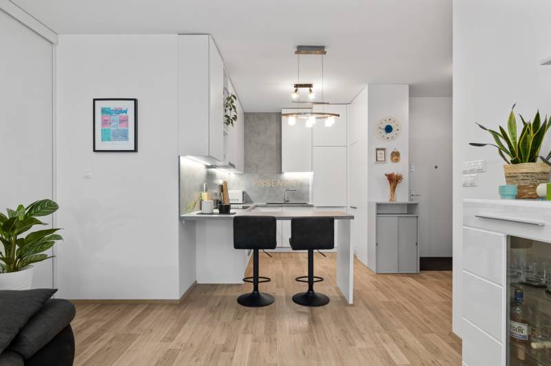 A kitchen in a 3-room apartment with a bar counter and a floor with a wooden decor.