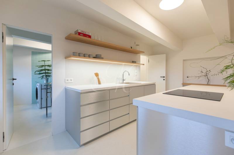 A kitchen in a 3-room apartment with a modern island and open storage space.