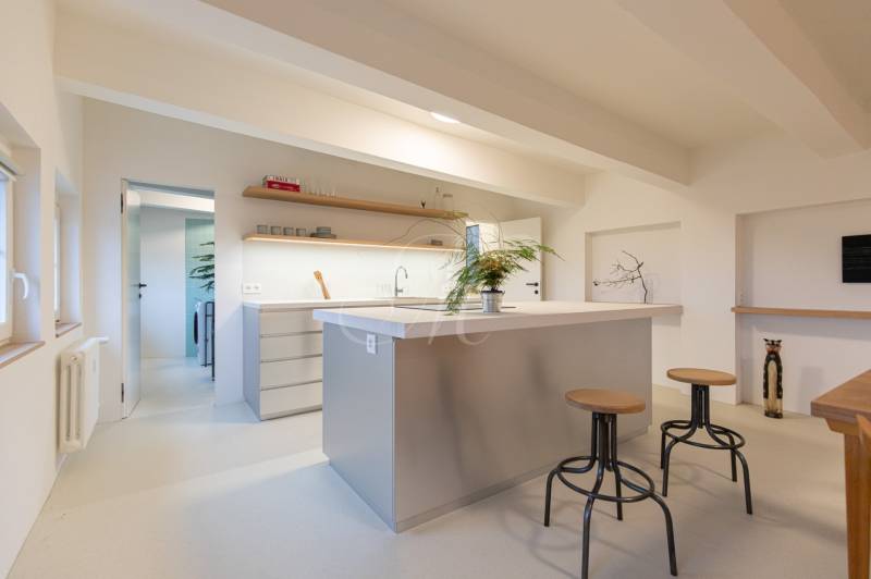Bright kitchen with an island and high chairs in a three-room apartment, floor with wood decor.