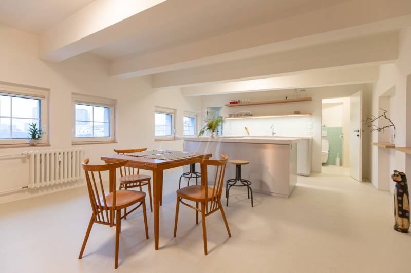 A bright kitchen in a 3-room apartment with wooden chairs and a table, white floor.