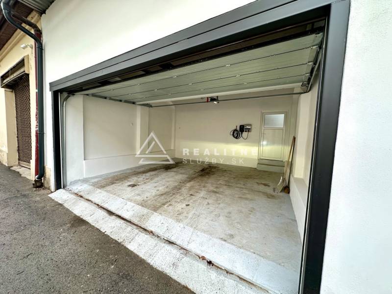 Open garage on Mäsiarska Street in Košice, Old Town, with white walls.