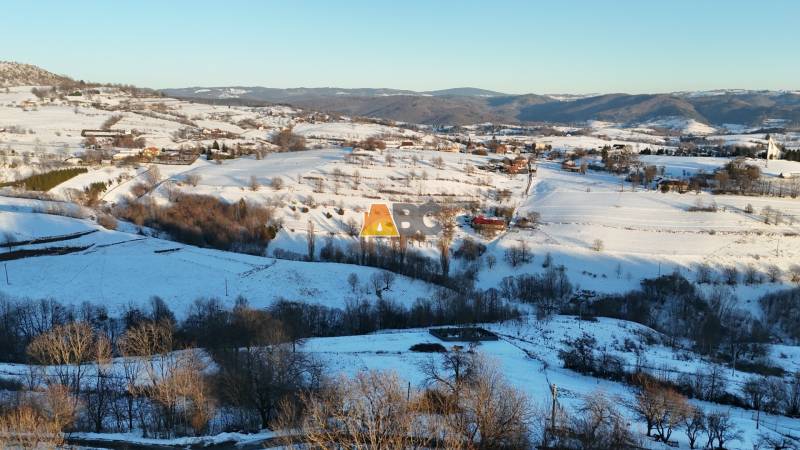 A snowy landscape of Hriňová in Zánemecká with scattered cottages, hills, and winter nature.