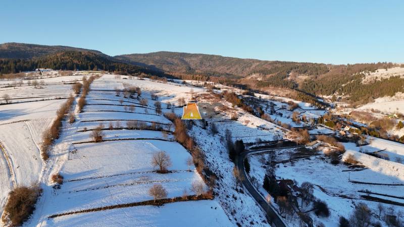 Snow-covered hills and forests surrounding the cabin in Hriňová on Zánemecká Street.
