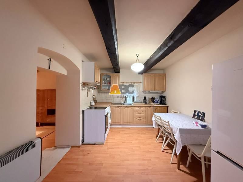 A kitchen in a cabin with a table, chairs, and a wooden-patterned floor.
