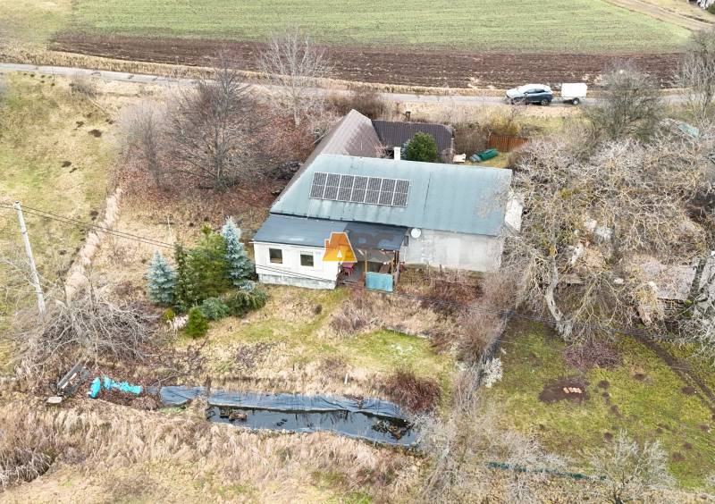 A cottage on Zánemecká in Hriňová with a meadow, trees, and solar panels on the roof.