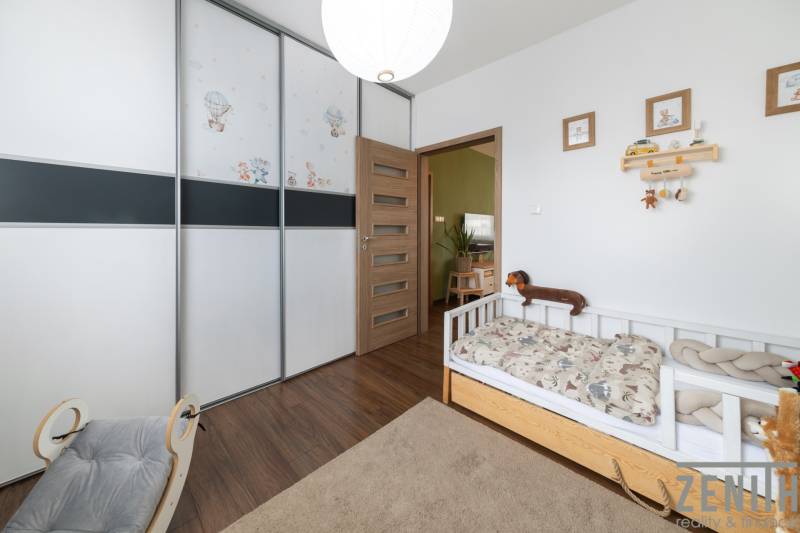 Children's room with a bed, built-in wardrobe, and wooden decor flooring in a 3-room apartment.