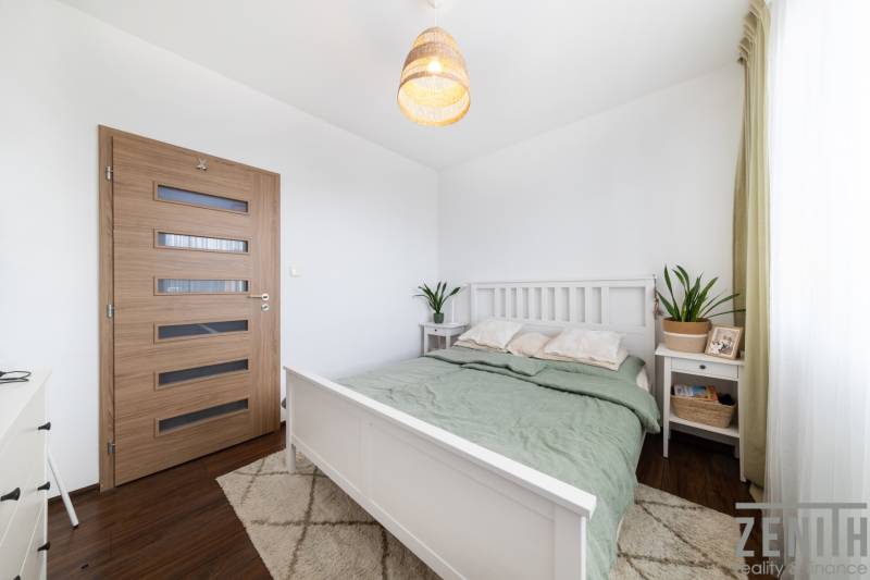 Bedroom in a 3-room apartment with a bed, nightstand, and floor with wood decor.