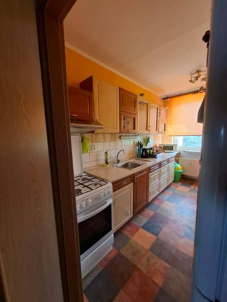 A colorful kitchen with a gas stove and flooring in a multi-room apartment.