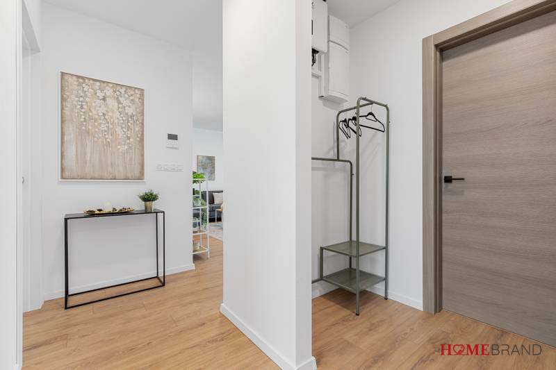Entrance hall in a 3-room apartment with a wooden decor floor and stylish furniture.