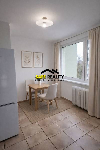 Dining area with two chairs in a 2-room apartment, light tiles, large window.