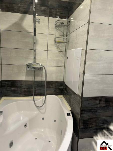 A bathroom with a modern shower and bathtub in a 3-room apartment.
