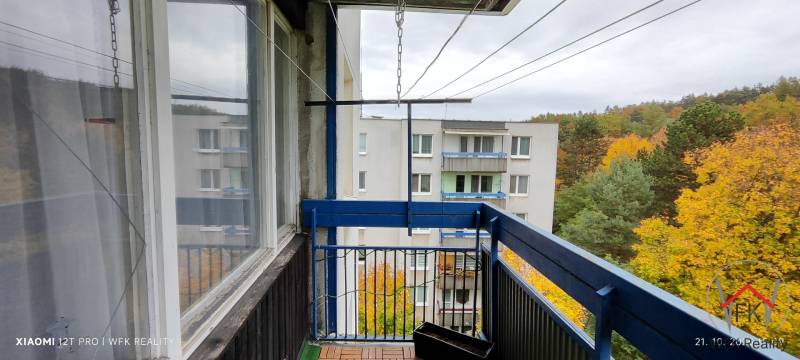 A balcony with a view of greenery and an apartment building in the 1. Mája housing estate, Vranov nad Topľou.