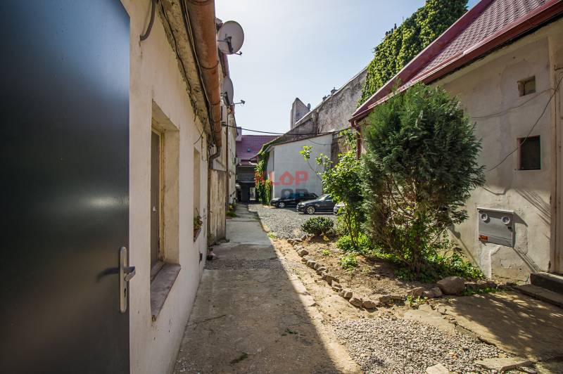 Courtyard between buildings on Obchodná Street in Bratislava - Old Town, with parking spaces.