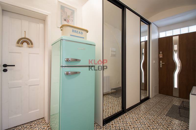 Entrance hallway with a vintage refrigerator in a studio apartment with decorative tiles.