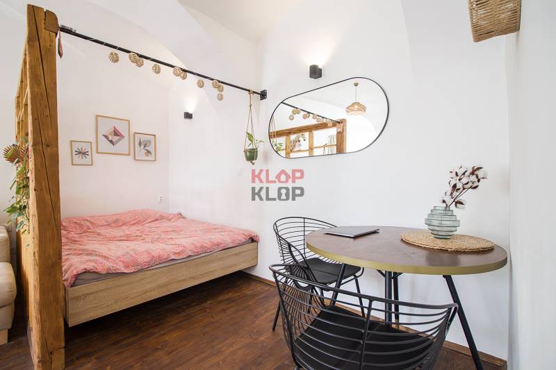 Stylish interior of a one-bedroom apartment with wood-patterned flooring and comfortable furniture.