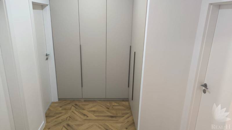 A hallway with a wooden decor floor and a built-in wardrobe in a 4-room apartment.