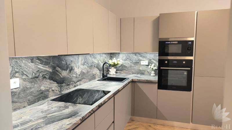 A kitchen in a 4-room apartment with a marble countertop and built-in appliances.