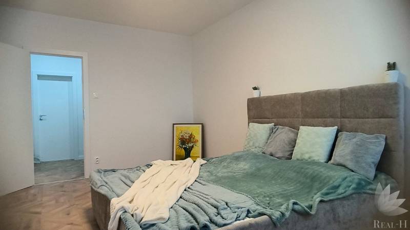 Bedroom in a 4-room apartment with a soft bed and decoration. Floor with wooden decor.
