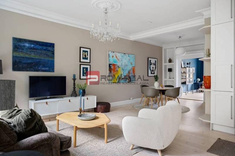 Living room in a 3-room apartment, light flooring with wood decor, stylish decorations.