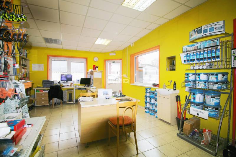Interior of production facilities with yellow walls, office furniture, and shelves with paints.