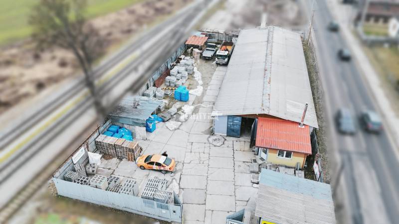 Production premises in Konská with cars and construction material near the railway track.