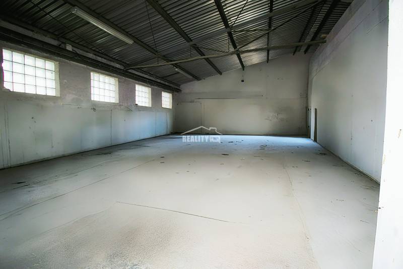 Spacious production facilities with concrete floors and large windows.