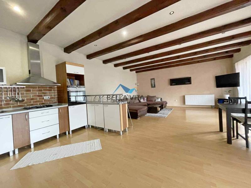 Interior of a family house with a kitchen, wooden decor flooring, and a living area.