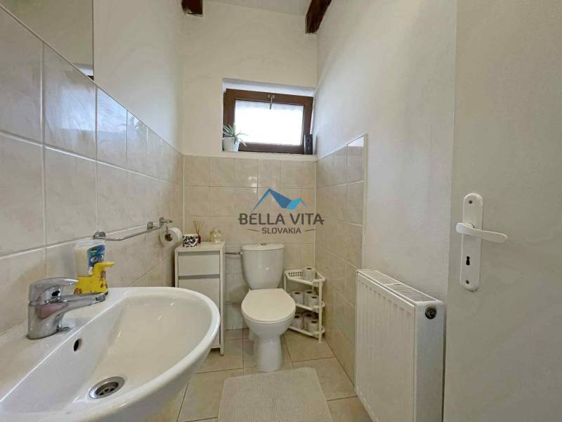 Bathroom in a family house with a sink, toilet, and radiator.