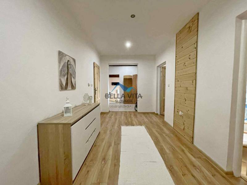 Hallway in a family house with a wooden decor floor and simple furniture.